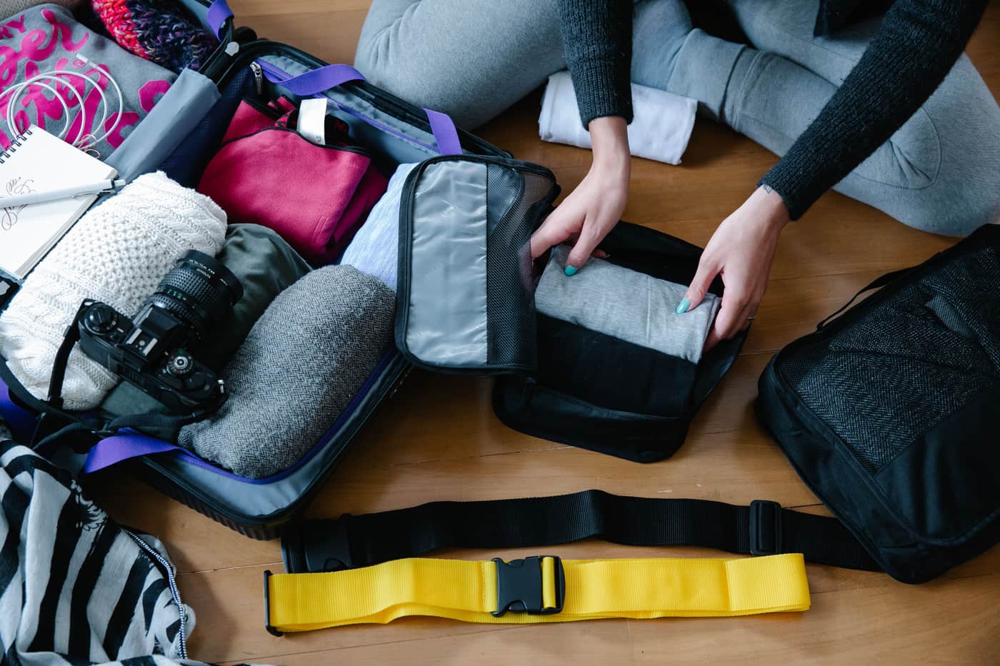 Packing cubes and folded clothes laid out in an open suitcase